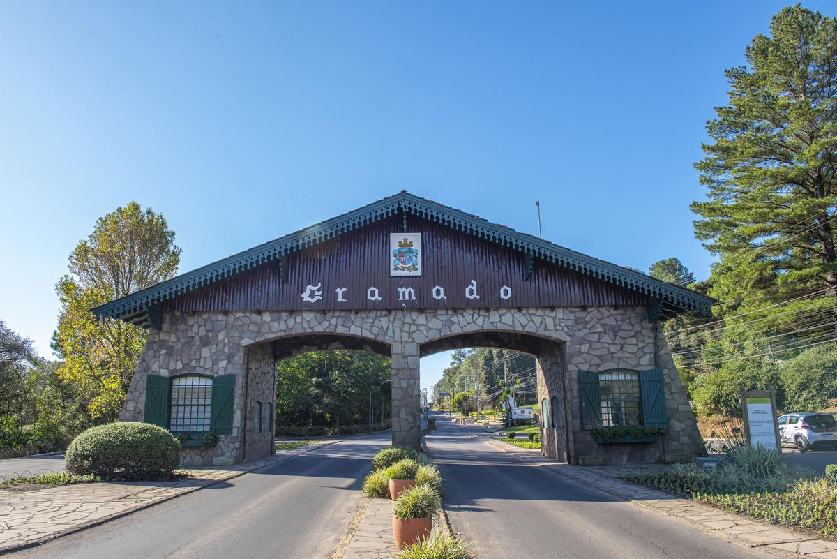 Vista panorâmica de Gramado ao entardecer, destacando luxuosas propriedades em meio à vegetação exuberante, idealizando Gramado como um investimento perfeito em valorização e bem-estar.